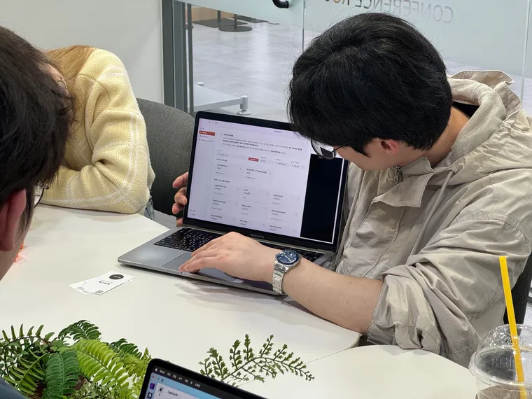 노트북 화면을 함께 들여다보는 참가자 두 명